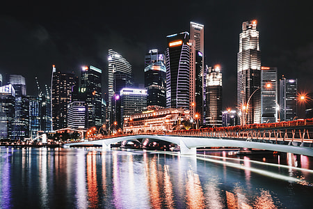 white concrete bridge near lighted high rise buildings during nighttime thumbnail