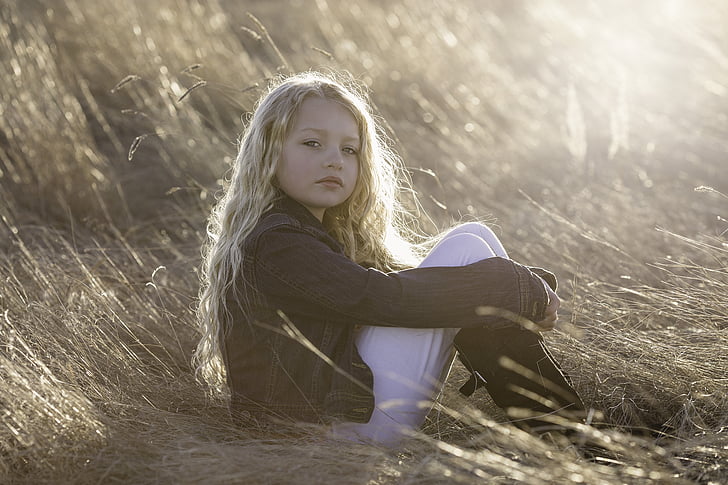 girl sitting on grass during daytime