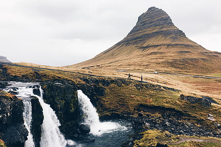 raging waterfalls near brown rock formation thumbnail