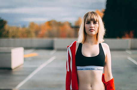 woman wearing black sports brassiere and red jacket thumbnail