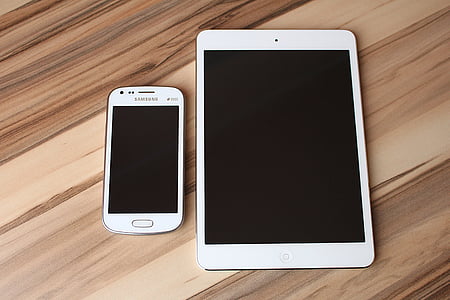 white Samsung Galaxy smartphones beside white iPad thumbnail