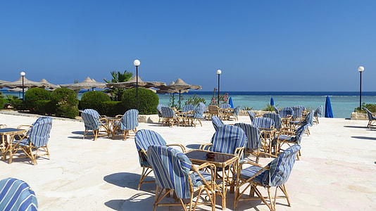 brown and blue table and chair set on seashore thumbnail