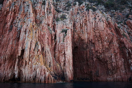 brown rock mountain on body of water thumbnail