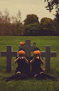 two women holding pumpkins in front of cross thumbnail