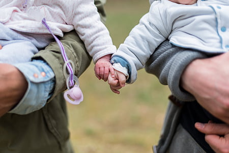 two babies holding each others hands thumbnail