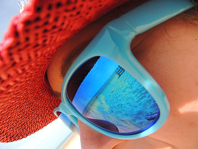 women's blue framed sunglasses and red hat thumbnail