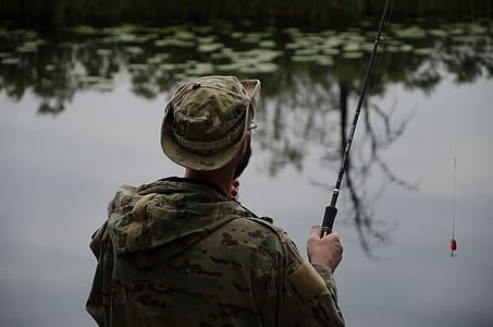 man fishing in the lake during daytime thumbnail
