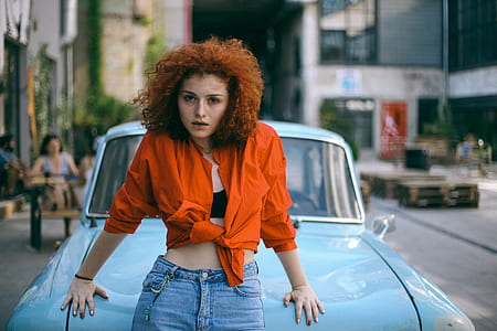 selective focus of woman standing behind car during daytime thumbnail