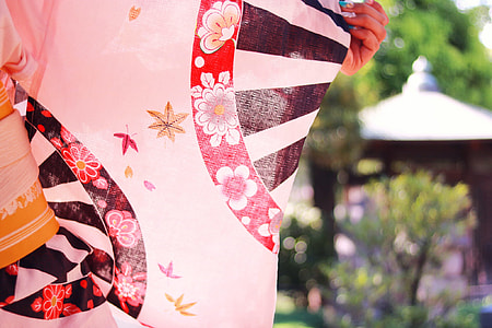 selective focus photography of a person holding red, black, and white floral textile thumbnail