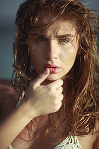 close-up photo of woman placing thumb on lip thumbnail