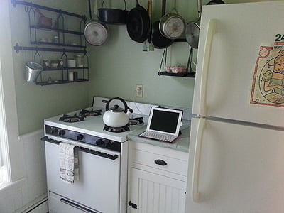 white tablet computer between of gas range and side-by-side refrigerator thumbnail