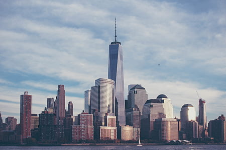 city buildings near body of water under cloudy sky during daytime thumbnail