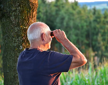 man in blue crew-neck shirt white using binocular thumbnail