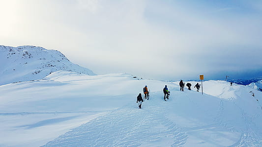people walking on snow under white clouds thumbnail