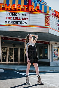 woman standing near Theatre under cloudy sky at daytime thumbnail
