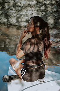 woman in black top and shorts sitting on white boat thumbnail