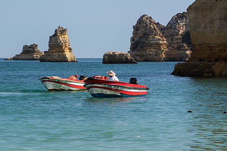 person sitting in boat beside another boat thumbnail