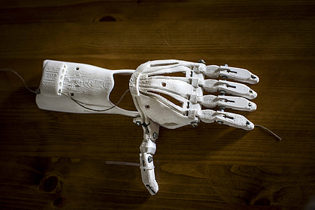 white prosthetic arm on brown wood surface thumbnail