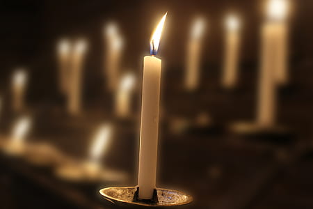 lighted white candle on grey candle holder thumbnail
