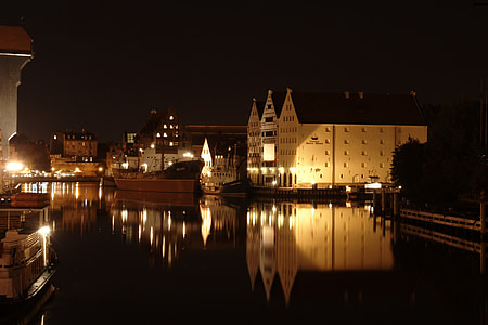 calm body of water near buildings at night thumbnail