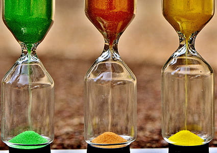 shallow focus photography of three assorted-color hour glasses thumbnail
