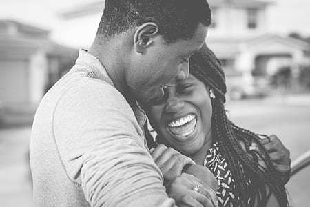 grayscale photo of man hugging woman laughing each other thumbnail