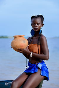 Woman Sitting on Boat Holding Brown Clay Pot thumbnail