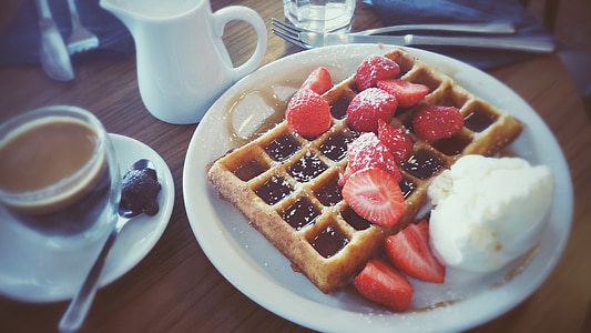 waffles and sliced strawberries on top of plate thumbnail