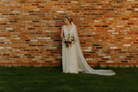 woman in white wedding gown holding bouquet of flowers thumbnail