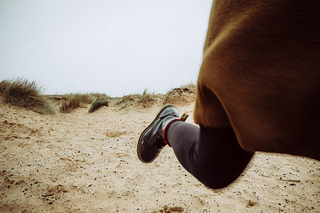 person walking in brown ground with grass thumbnail