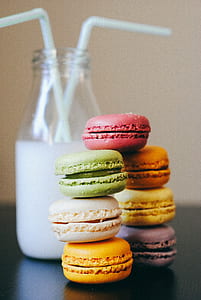 seven assorted-color French macaroons beside bottle of milk drink thumbnail