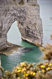 gray arch rock formation on body of water thumbnail