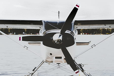 white and black biplane park on body of water thumbnail
