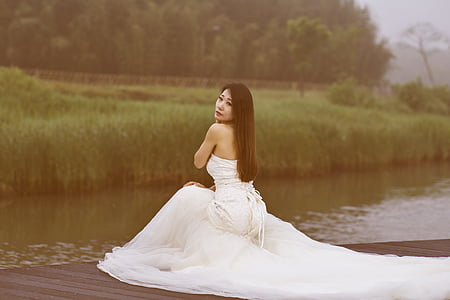 woman wearing white dress kneeling beside lake thumbnail
