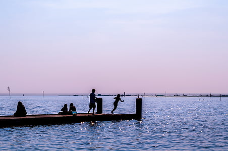 silhouette of people at dock surrounded by body of water thumbnail