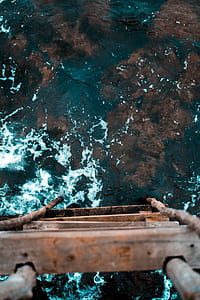 brown wooden ladder near body of water thumbnail