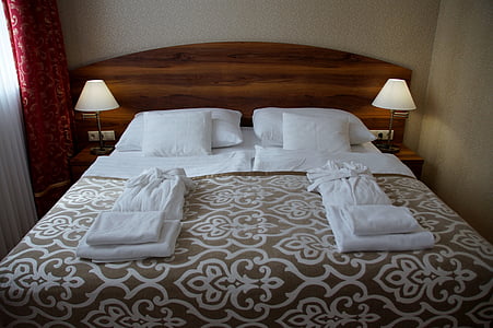 blankets, towels, bathrobe, and pillows on bed thumbnail