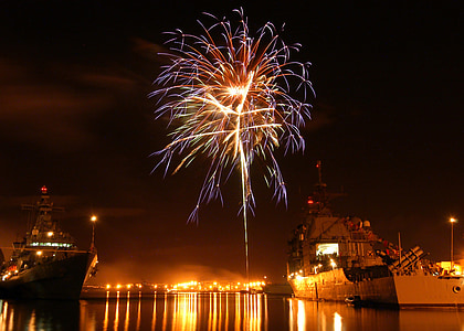 fireworks between two gray ships dock on water during night time thumbnail
