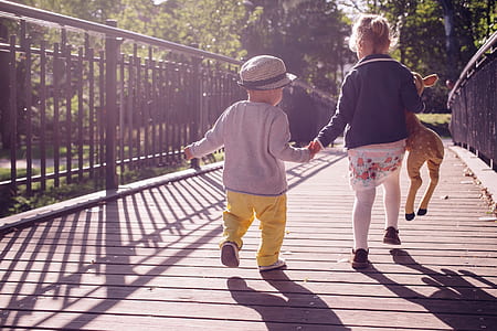 two children walking along a wooden bridge thumbnail