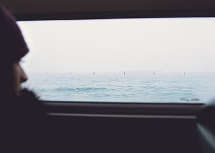 man sitting inside vehicle looking at the body of water thumbnail