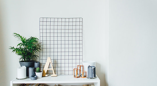white wooden table with plants, and gray containers on top thumbnail