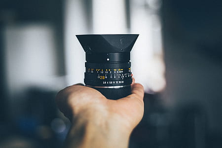 person holding black telephoto lens thumbnail