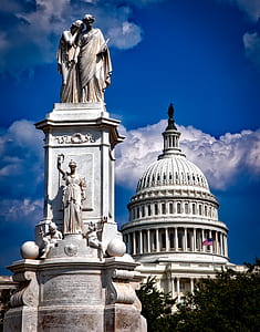 man and woman statue under blue clouds thumbnail