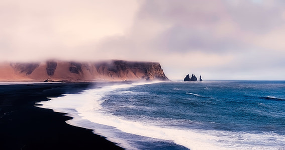 seashore with calm waves under gray skies thumbnail