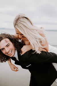 man carrying woman on back smiling thumbnail