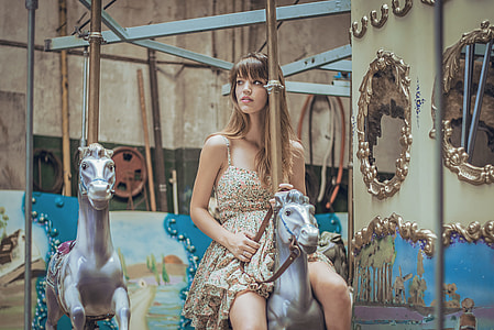 woman in brown spaghetti strap dress riding carousel thumbnail