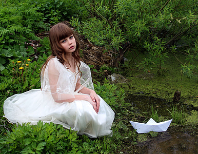 girl wearing white gown sitting on grass thumbnail