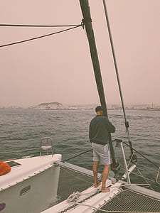 man standing on the deck of a boat thumbnail