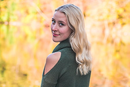 selective focus photography of woman wearing green cold-shoulder sweater thumbnail