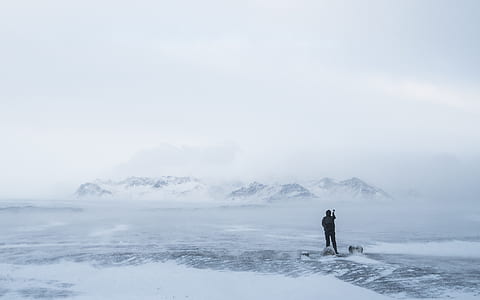 landscape photography of man standing on ice field thumbnail